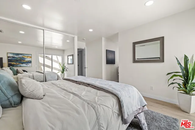 a bedroom with a bed and a potted plant
