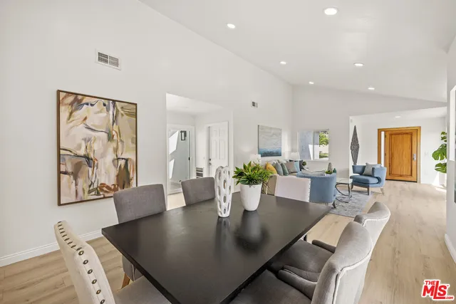 a living room with furniture large window and wooden floor