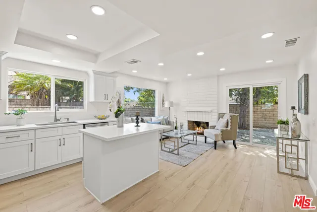 a living room with fireplace furniture and a large window