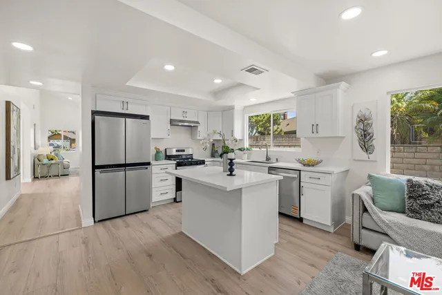 a kitchen with white cabinets and stainless steel appliances
