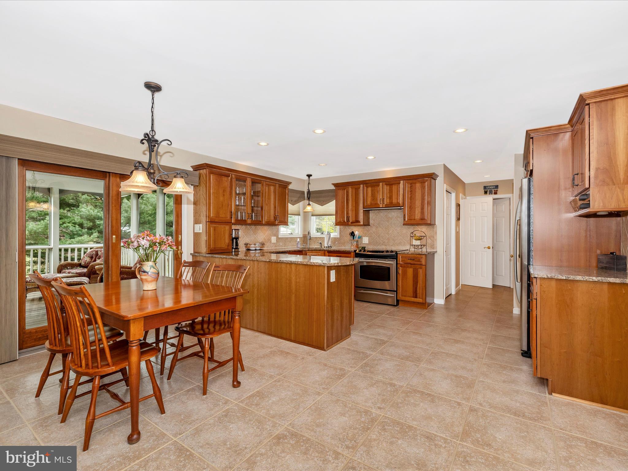 4945 Jalmia Road Mount Airy, MD 21771 - Photo 8 of 45 a kitchen with stainless steel appliances a dining table chairs stove and refrigerator