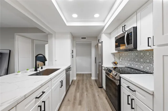 a kitchen with a sink stove and cabinets