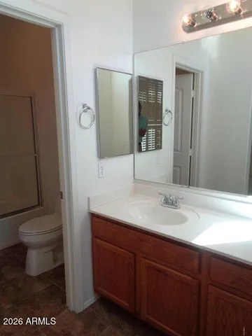 a bathroom with a granite countertop sink toilet and mirror