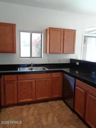 a kitchen with granite countertop cabinets a sink and a large window