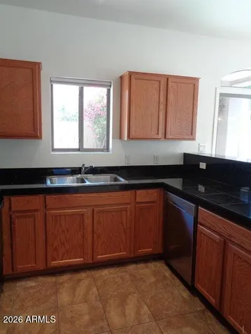 a kitchen with granite countertop cabinets a sink and a large window