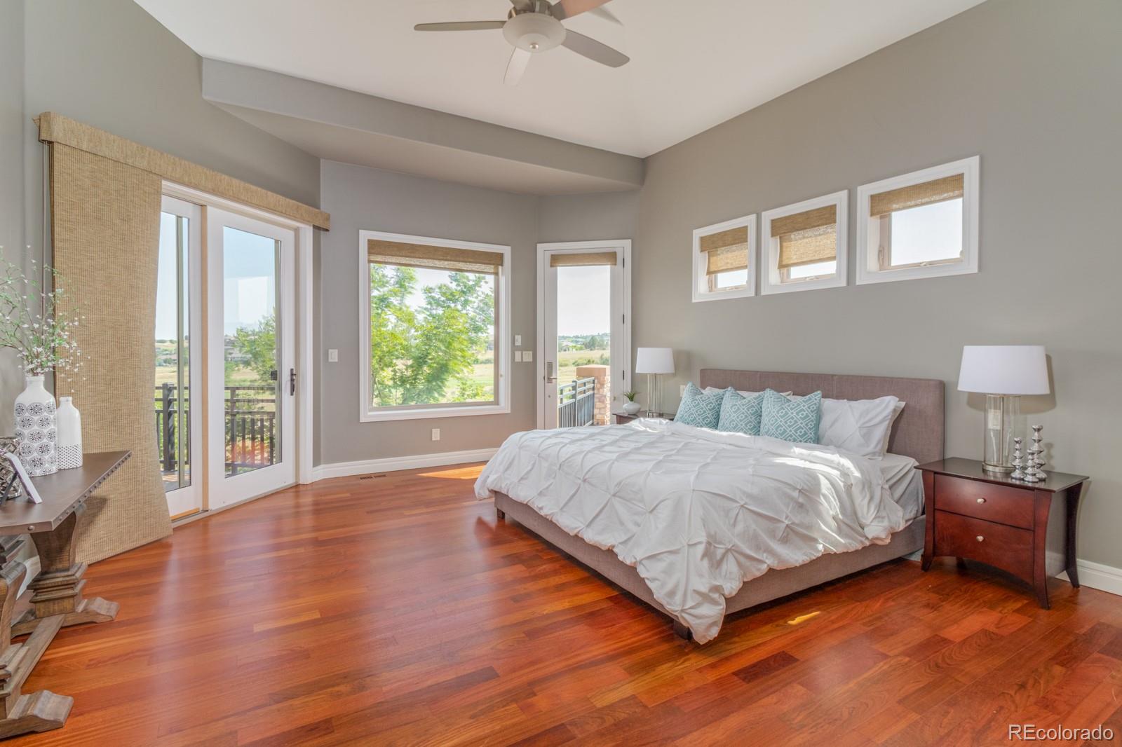 5241 Raintree Circle Parker, CO 80134 - Photo 14 of 36 a spacious bedroom with a large bed and a chandelier