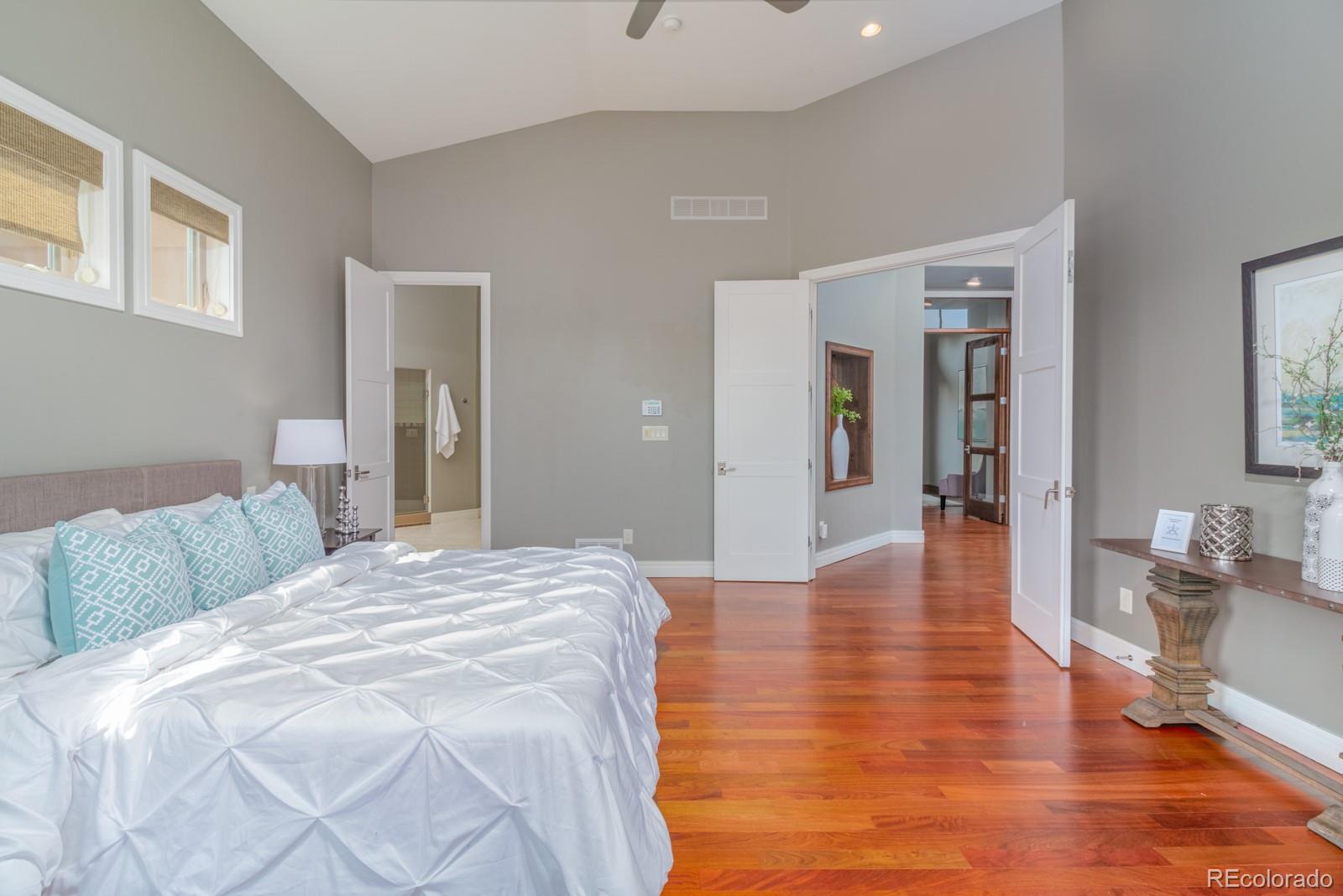5241 Raintree Circle Parker, CO 80134 - Photo 17 of 36 a spacious bedroom with a bed and a wooden floor
