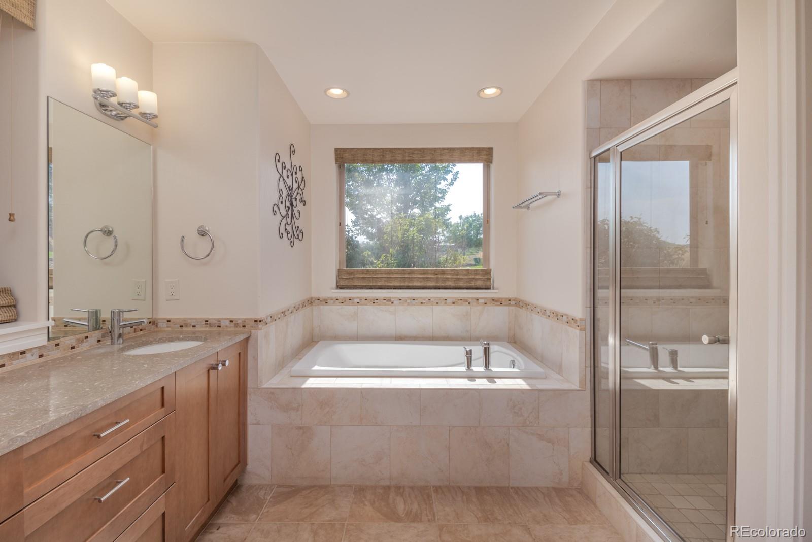 5241 Raintree Circle Parker, CO 80134 - Photo 25 of 36 a spacious bathroom with a granite countertop tub sink and mirror