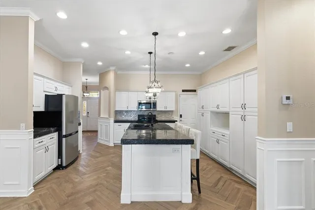 a view of an empty room and kitchen view
