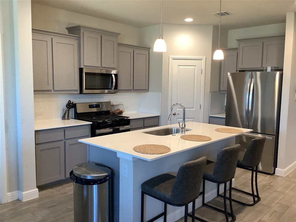 156 Hawksbill Lane Rhome, TX 76078 - Photo 7 of 19 a kitchen with stainless steel appliances a table chairs sink refrigerator and microwave