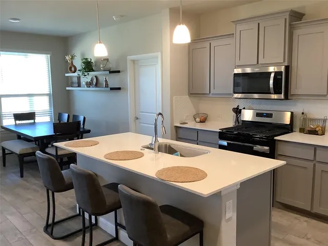 a kitchen with a stove a sink and a refrigerator