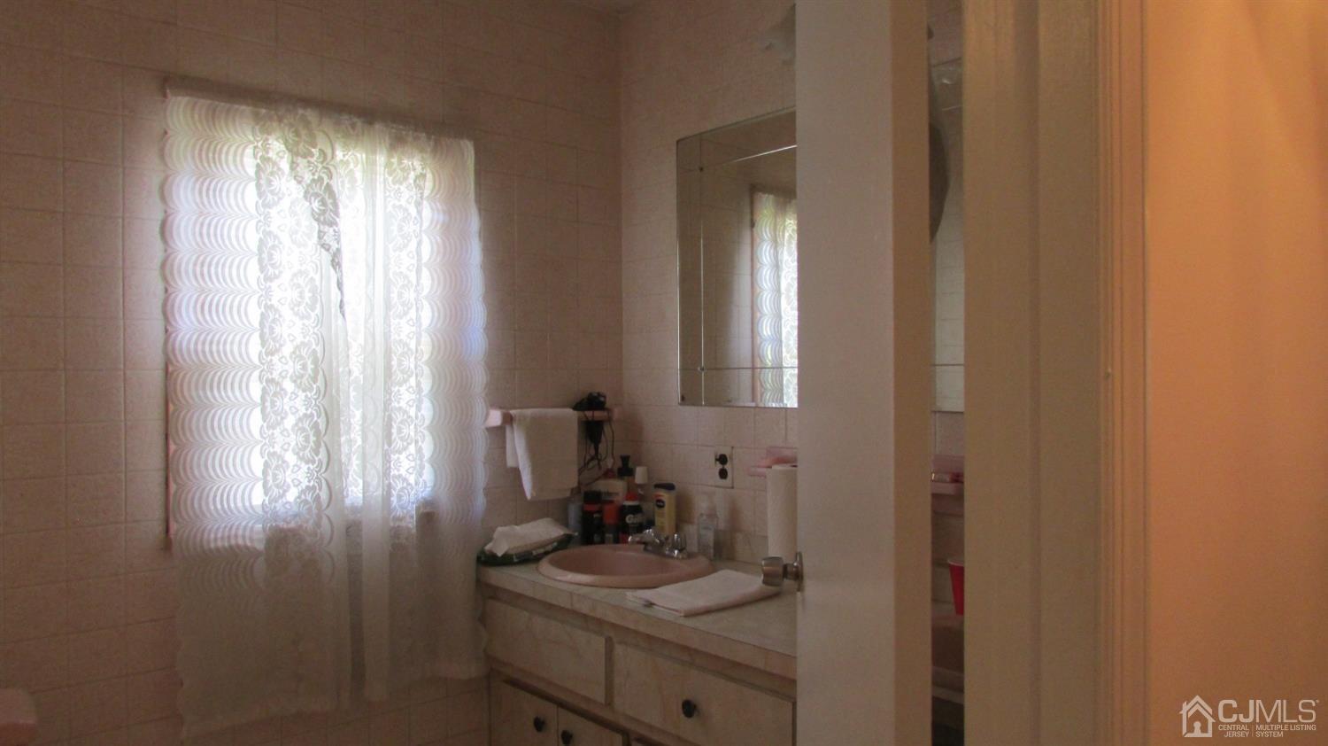 19 Hillsdale Road Edison, NJ 08820 - Photo 12 of 13 a bathroom with a sink a window and a mirror