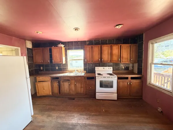 a kitchen with a white stove top oven sink and window