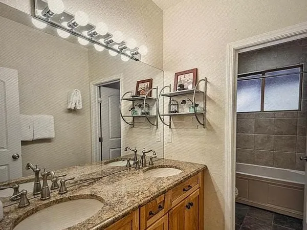 a bathroom with a granite countertop sink a mirror and vanity