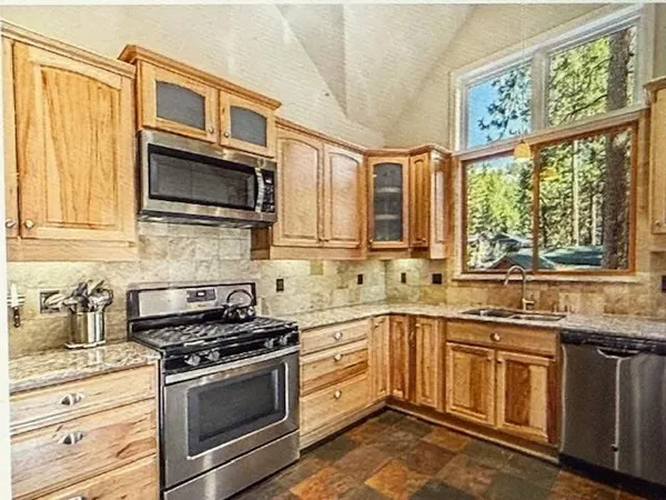 a kitchen with stainless steel appliances a stove sink microwave and cabinets