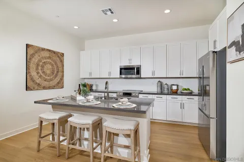 a kitchen with cabinets stainless steel appliances a sink and wooden floor