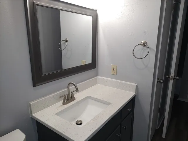 a bathroom with a sink and mirror with toilet
