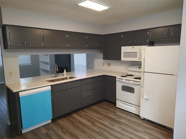 a kitchen with a cabinets and white appliances