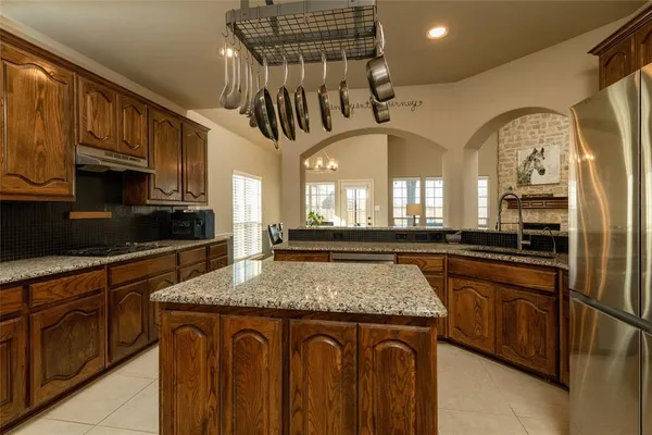 a kitchen with stainless steel appliances granite countertop a sink a stove cabinets counter space and a window