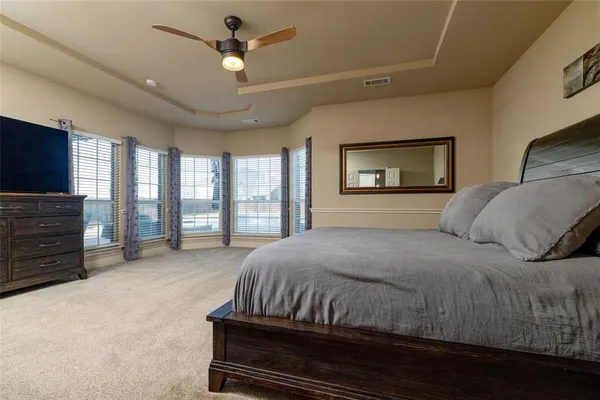 a spacious bedroom with a bed and glass door