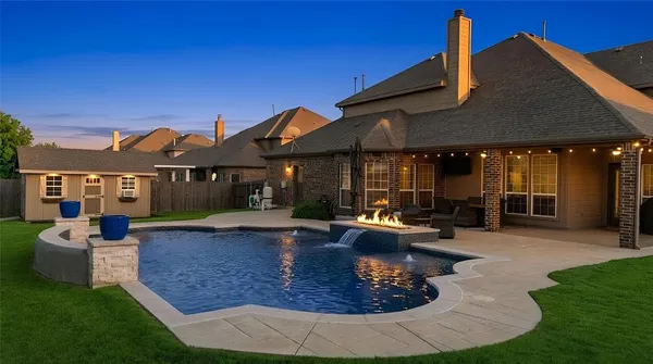 a view of a house with backyard sitting area and swimming pool