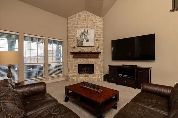 a living room with furniture a flat screen tv and a fireplace