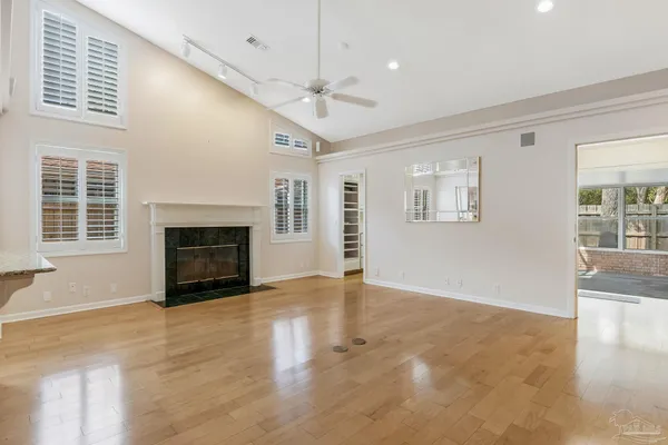 a view of empty room with wooden floor and fireplace