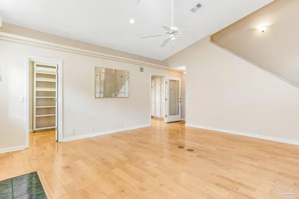 an empty room with wooden floor and windows
