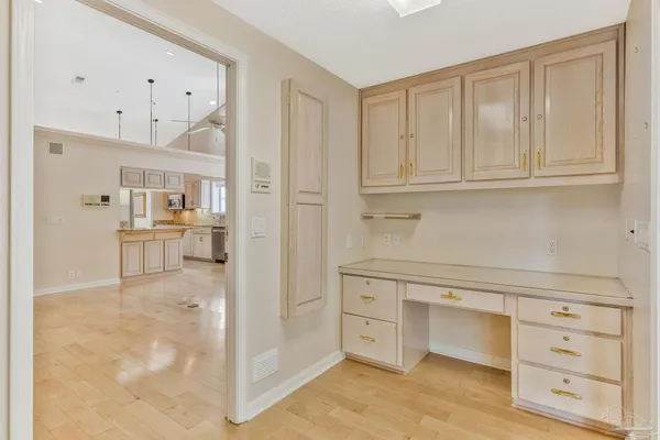 a view of a kitchen with white cabinets and wooden floor