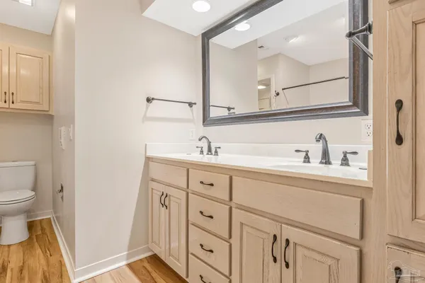 a spacious bathroom with a sink a toilet a mirror and shower