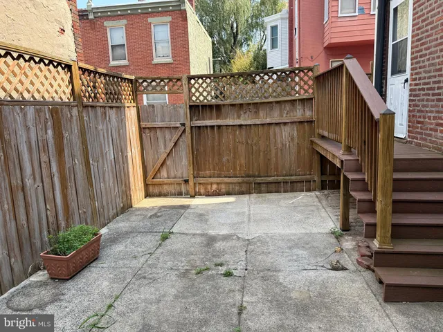 a view of a backyard with potted plants and wooden fence