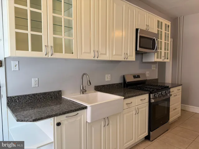 a kitchen with stainless steel appliances granite countertop a sink a stove and a microwave