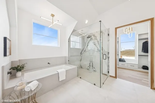 a spacious bathroom with a tub shower and mirror