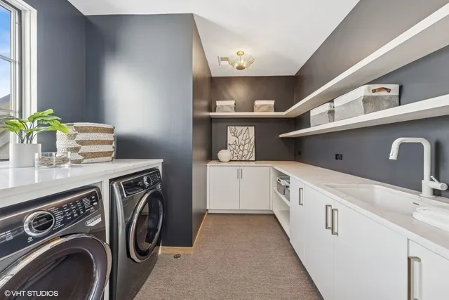 a utility room with cabinets washer and dryer