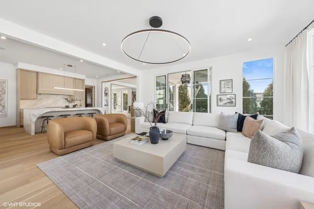 a living room with furniture ceiling fan and a large window