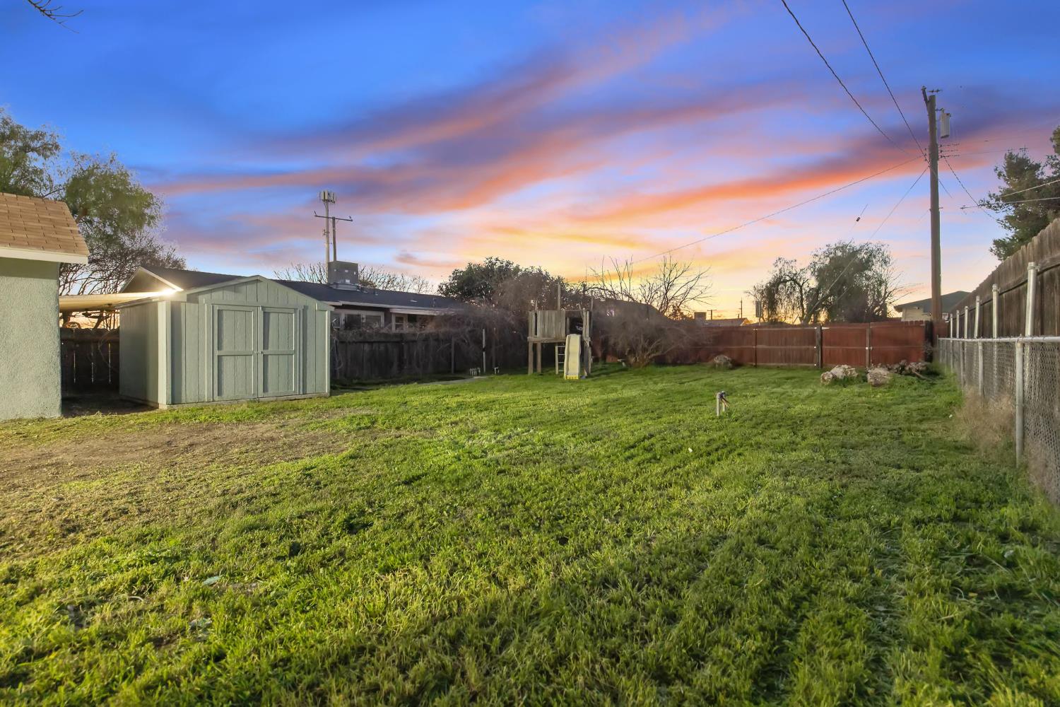 1402 Middleton Street Hanford, CA 93230 - Photo 35 of 40 a backyard of a house with plants and large tree