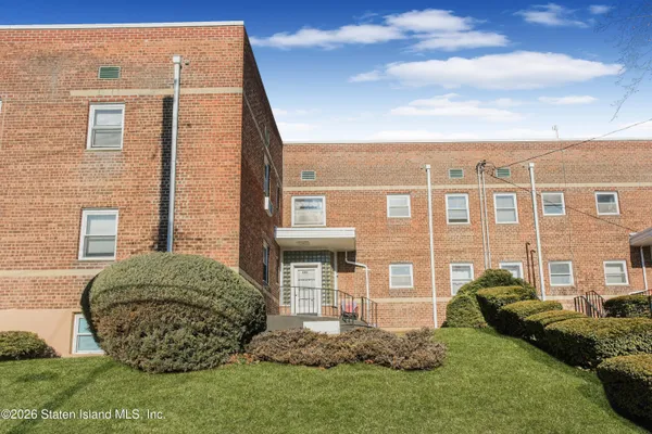 a view of a brick house with a yard