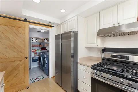 a kitchen with a refrigerator and a stove top oven