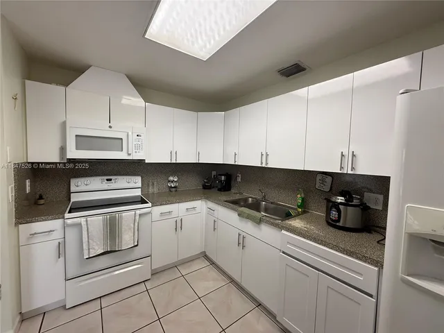 a kitchen with cabinets appliances and a sink