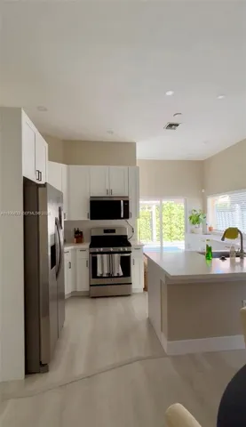 a kitchen with stainless steel appliances a refrigerator and a stove top oven