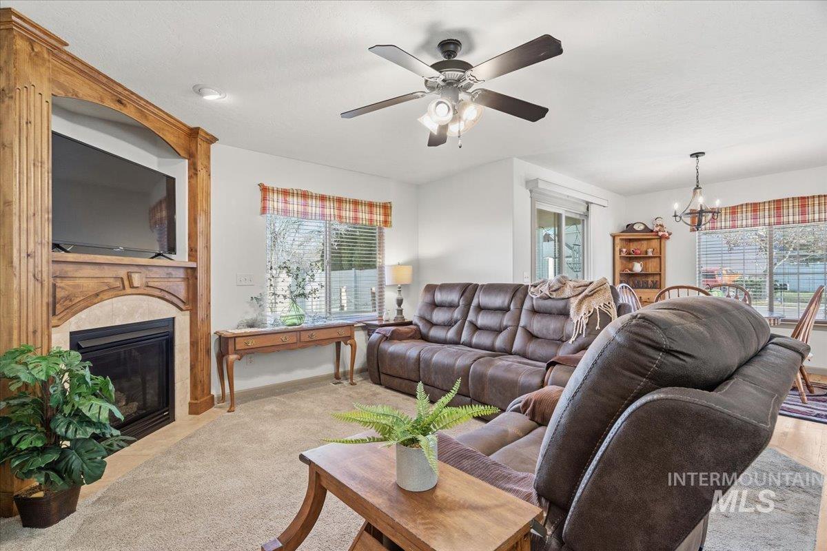 679 North Shadowfox Place Eagle, ID 83616 - Photo 12 of 28 Living room with a chandelier, a large fireplace, carpet floors, and healthy amount of natural light