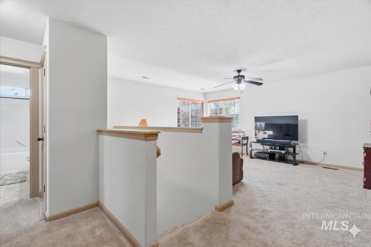 679 North Shadowfox Place Eagle, ID 83616 - Photo 17 of 28 Hall with an upstairs landing, light carpet, and a textured ceiling
