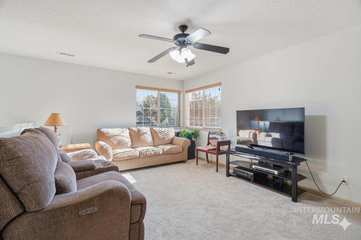 679 North Shadowfox Place Eagle, ID 83616 - Photo 19 of 28 Carpeted living area featuring a ceiling fan