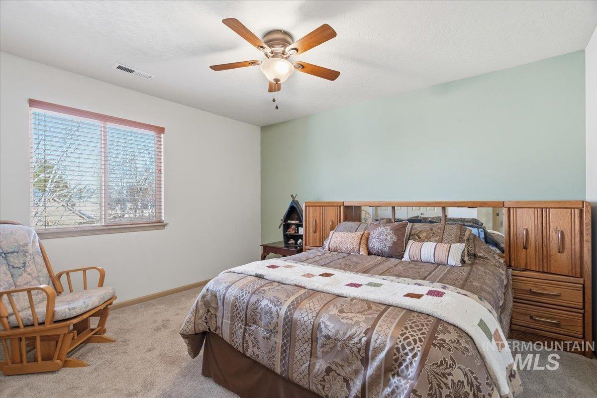 679 North Shadowfox Place Eagle, ID 83616 - Photo 26 of 37 Carpeted bedroom with a ceiling fan and a textured ceiling