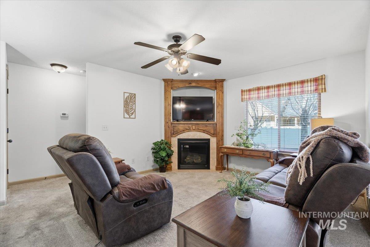 679 North Shadowfox Place Eagle, ID 83616 - Photo 6 of 28 Carpeted living area with a fireplace and a ceiling fan
