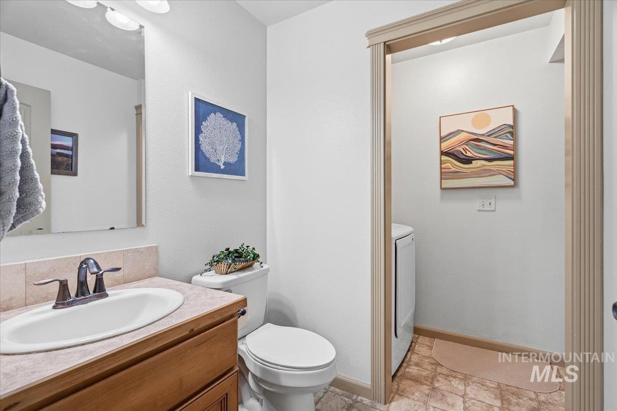 679 North Shadowfox Place Eagle, ID 83616 - Photo 6 of 37 Half bathroom with vanity and washer / dryer