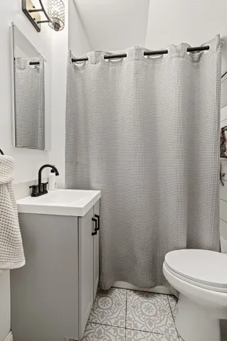 a bathroom with a sink a toilet a shower and a mirror