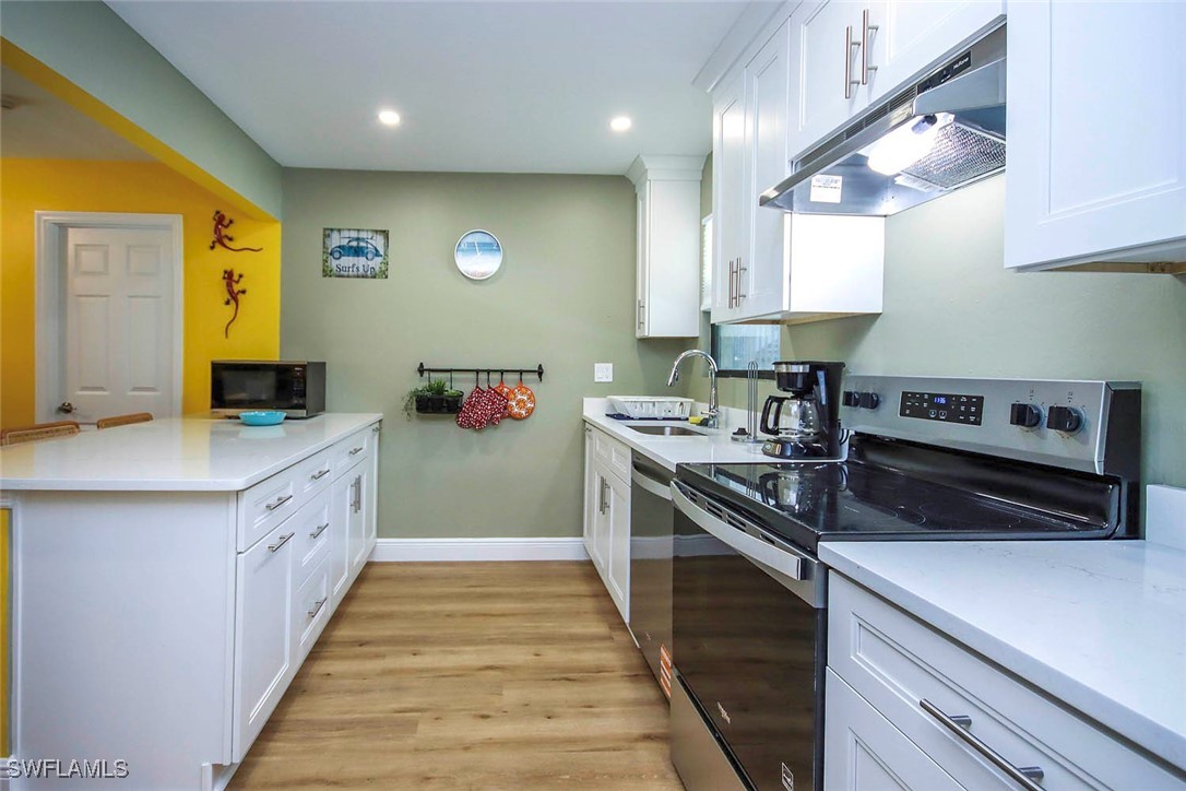 5117 Sea Bell Road, Unit B101 Sanibel, FL 33957 - Photo 6 of 23 a kitchen with stainless steel appliances a sink stove and cabinets