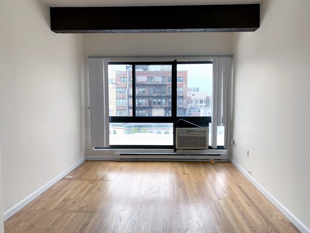 a view of a room with wooden floor and a window