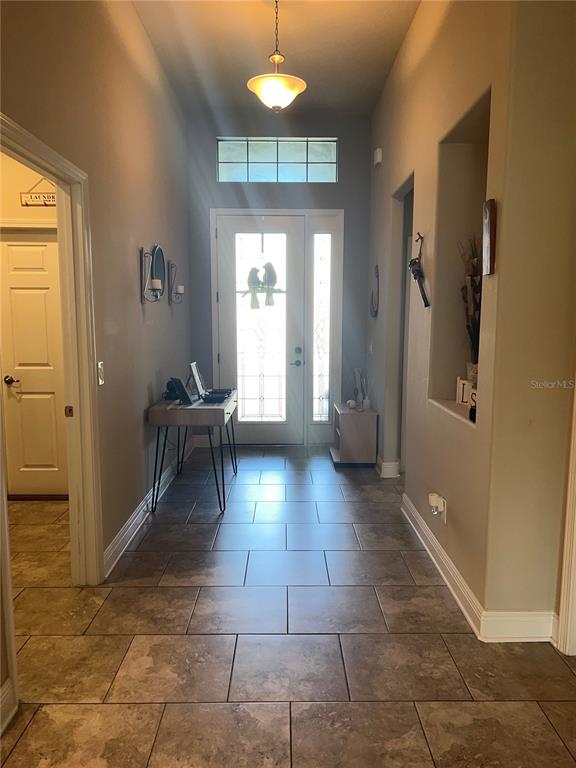 1597 West Caroline Path Lecanto, FL 34461 - Photo 2 of 28 a view of a hallway with furniture and a chandelier